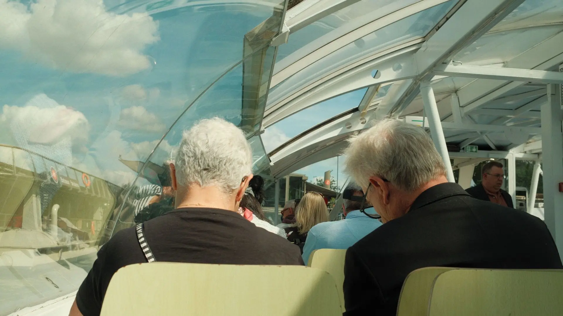 Passengers under the glass roof of a river boat on the Seine